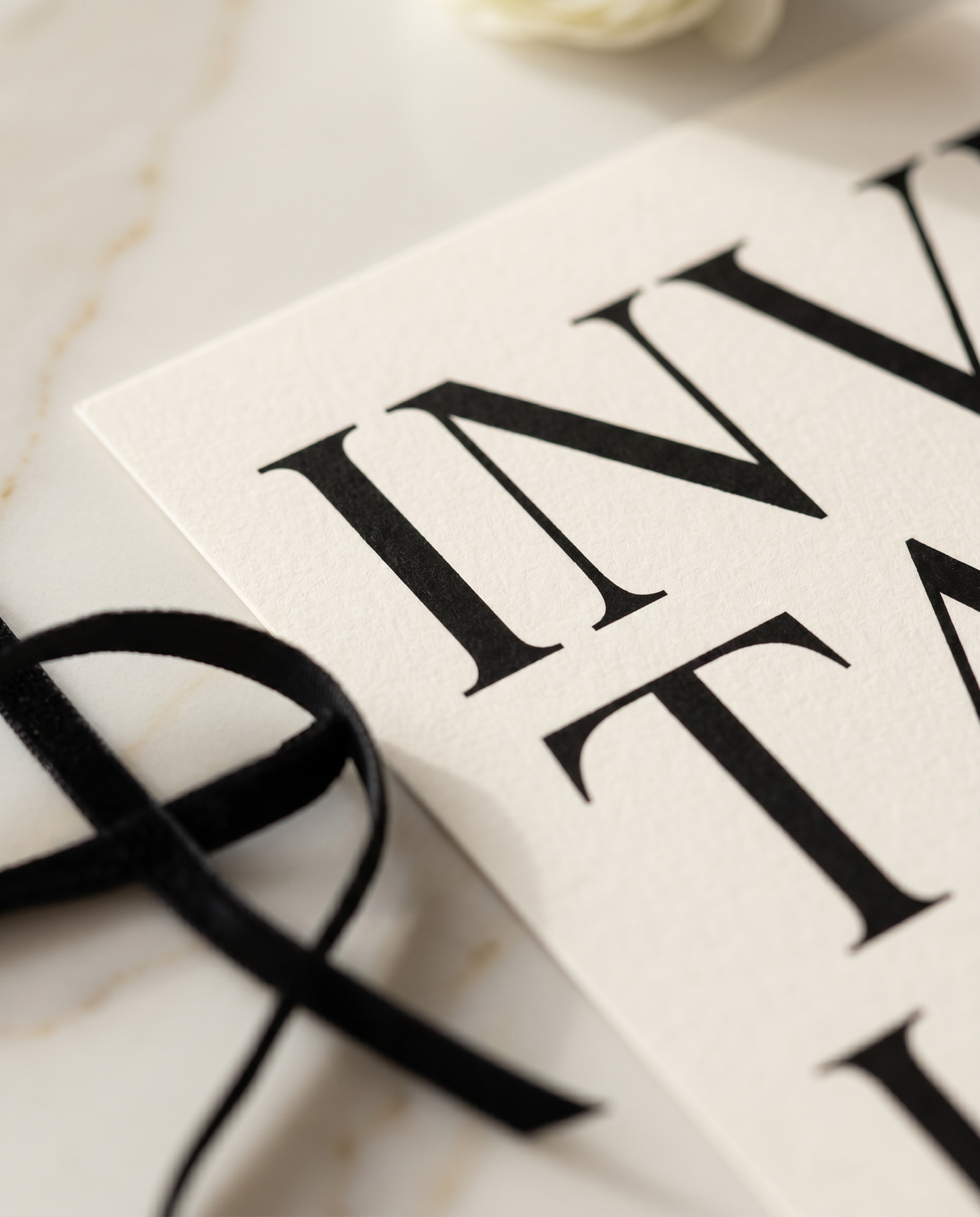 Minimalist editorial wedding invitation close-up detail on marble