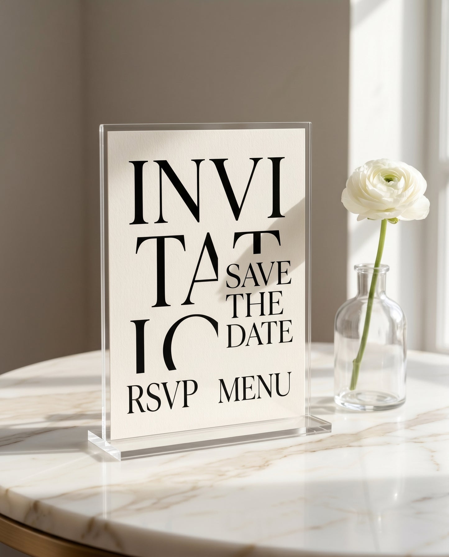 Minimalist wedding invitation displayed in a stand on marble