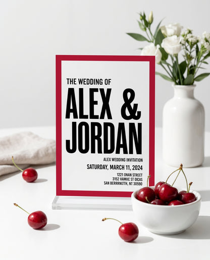 Cherry red wedding invitation displayed in a stand with cherries